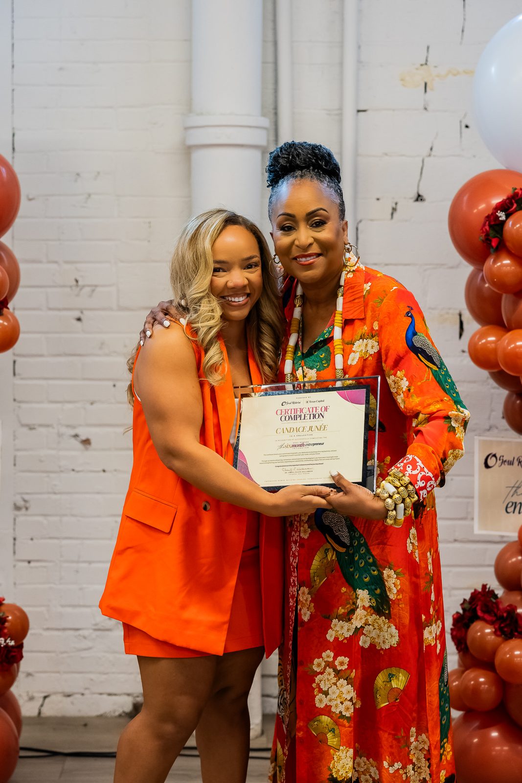 A graduate holding her certificate of completion with founder Cheryl Polote-Williamson